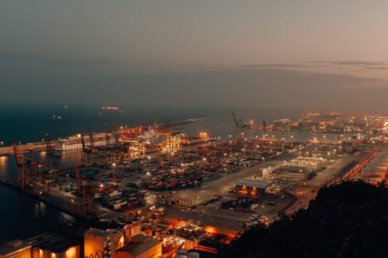 A distant shot of a port with boats loaded with cargo and shipment during nighttime